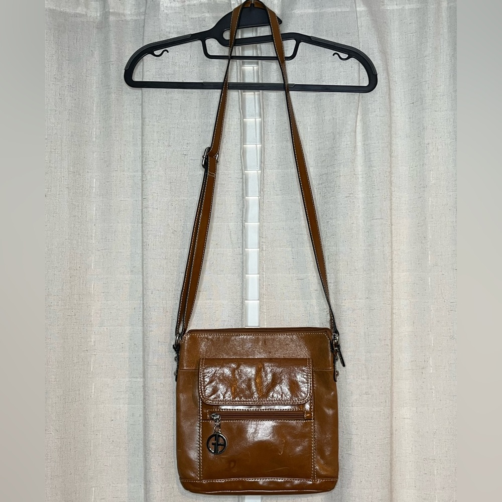 Brown leather crossbody bag with zipper closure and multiple pockets
